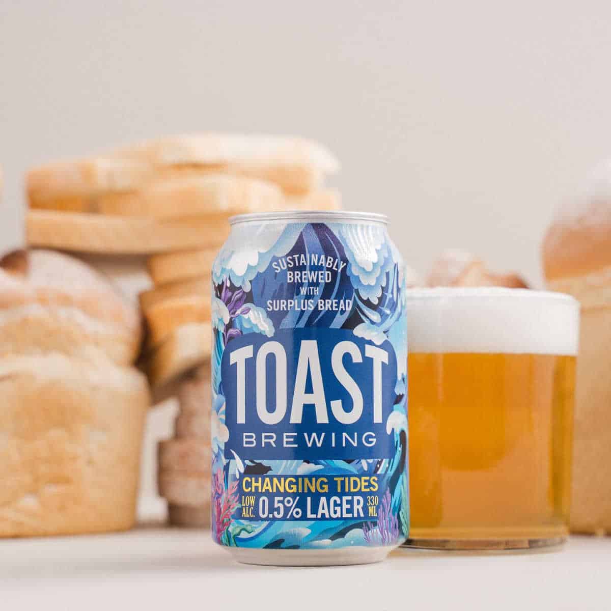 Can of sustainable beer from Toast brewing with loaves of bread in the background.