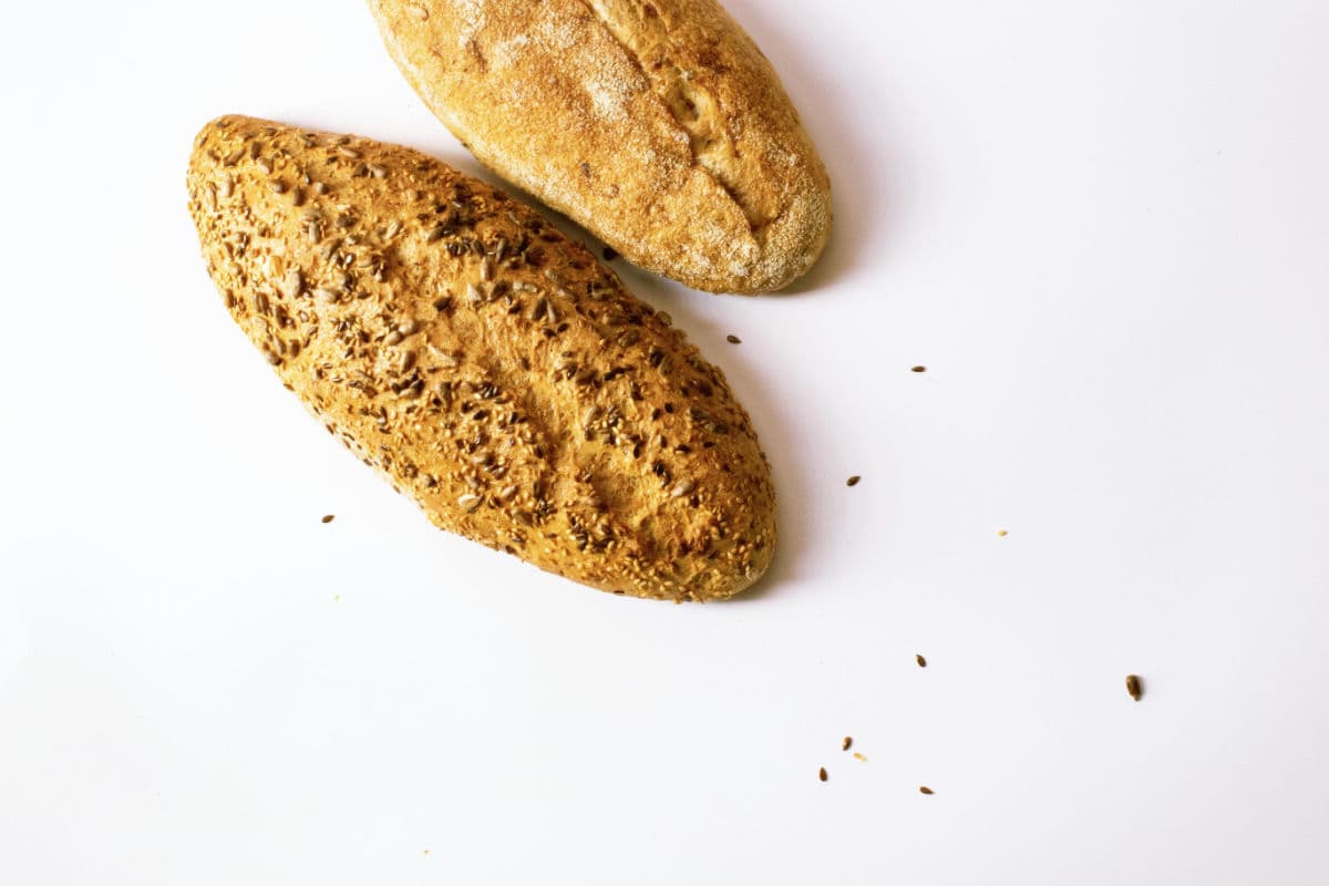 Two loaves on bread on a white work surface.